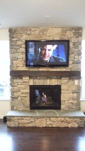 tv mounted over a brick fireplace